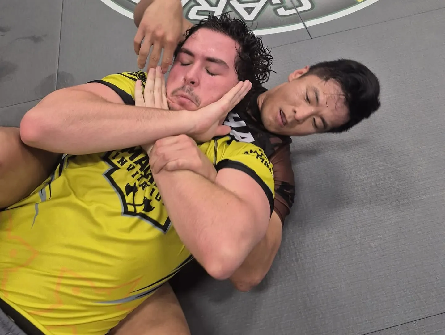 Two adult Machado Method students rolling during a Brazilian Jiu-Jitsu class in Carrollton, TX
