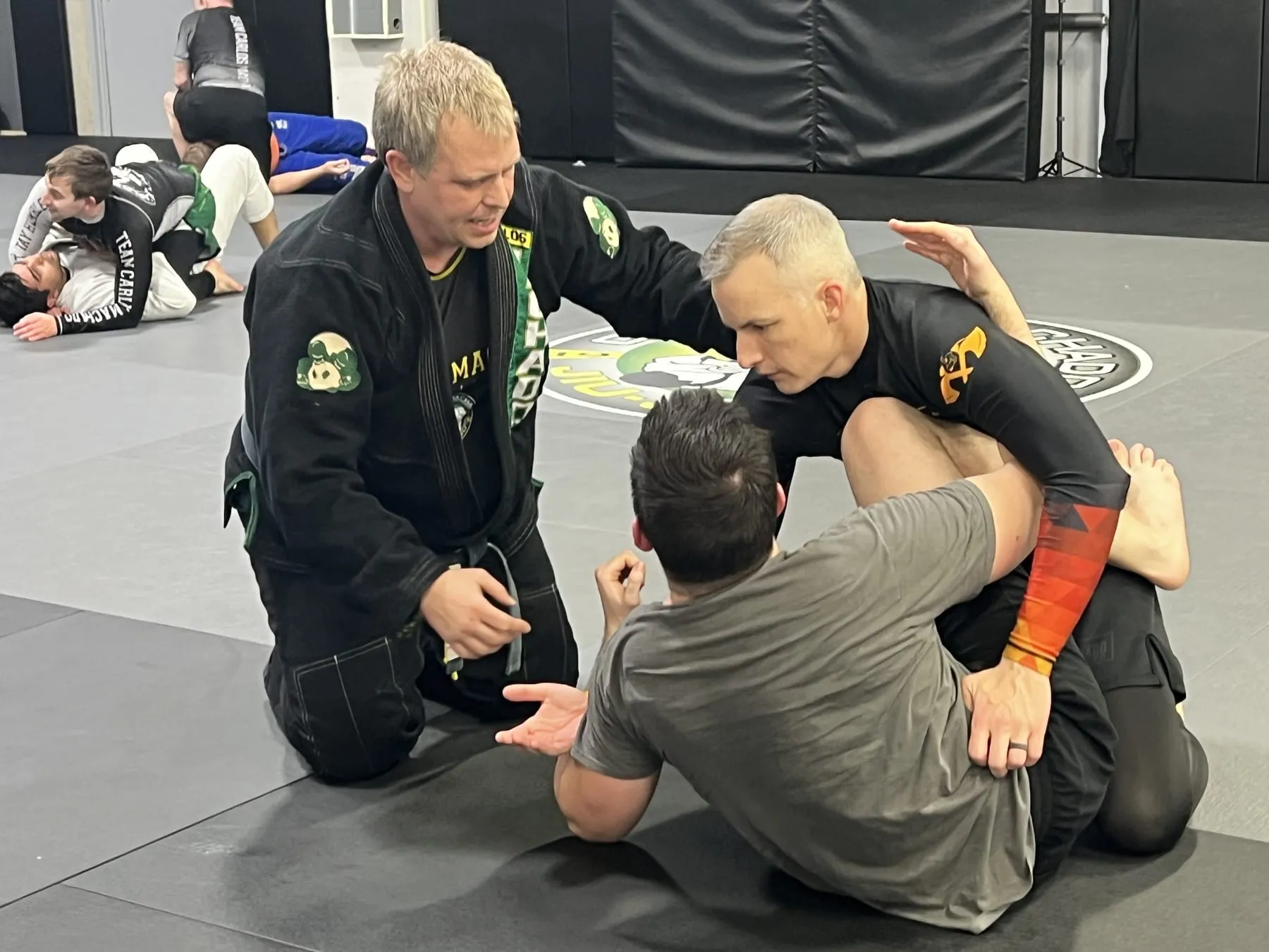 A Machado Method coach walking two students through a technique during class in Carrollton, TX