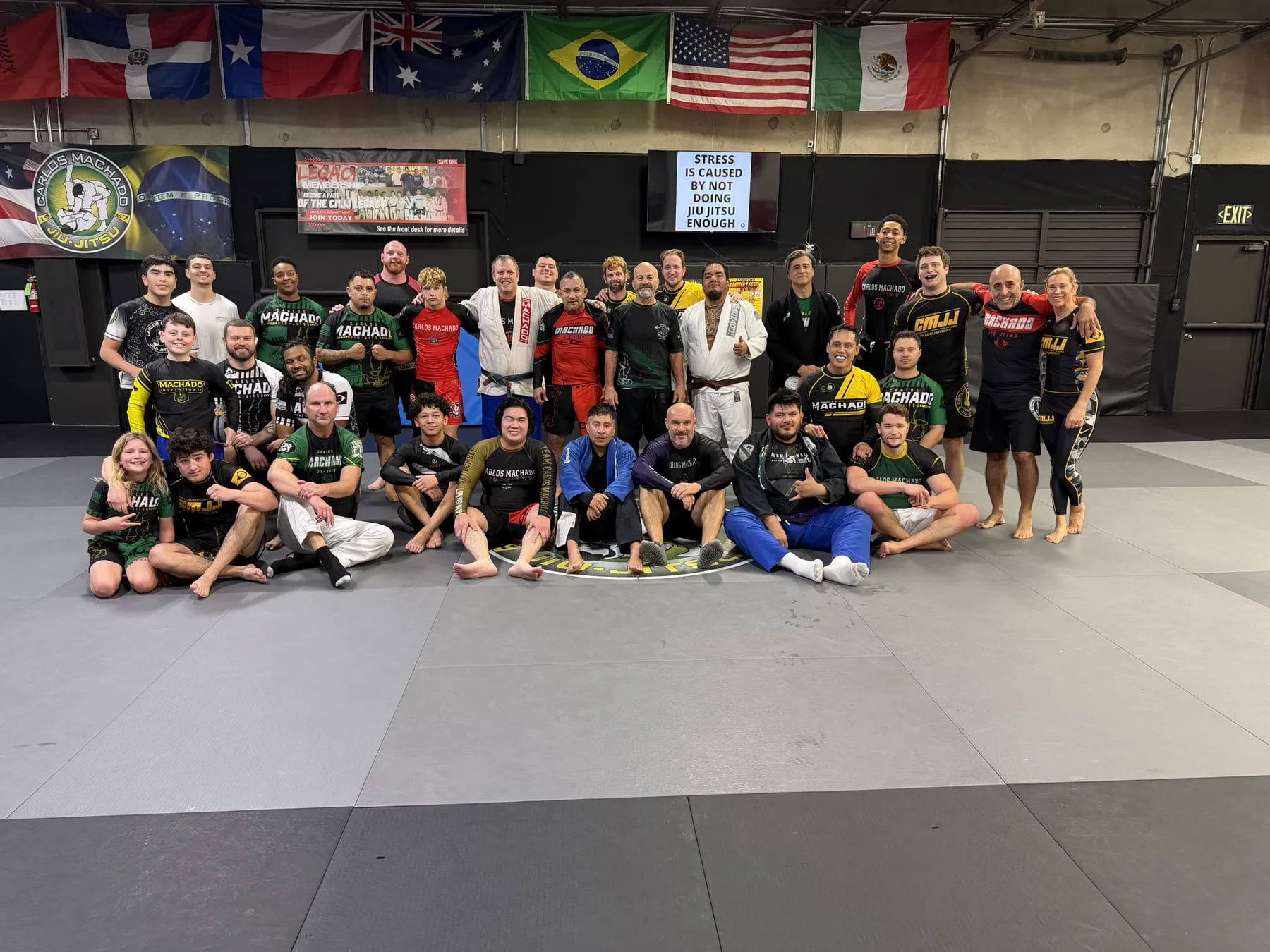 The Machado Method adult team together on the mat under the flags in Carrollton, TX