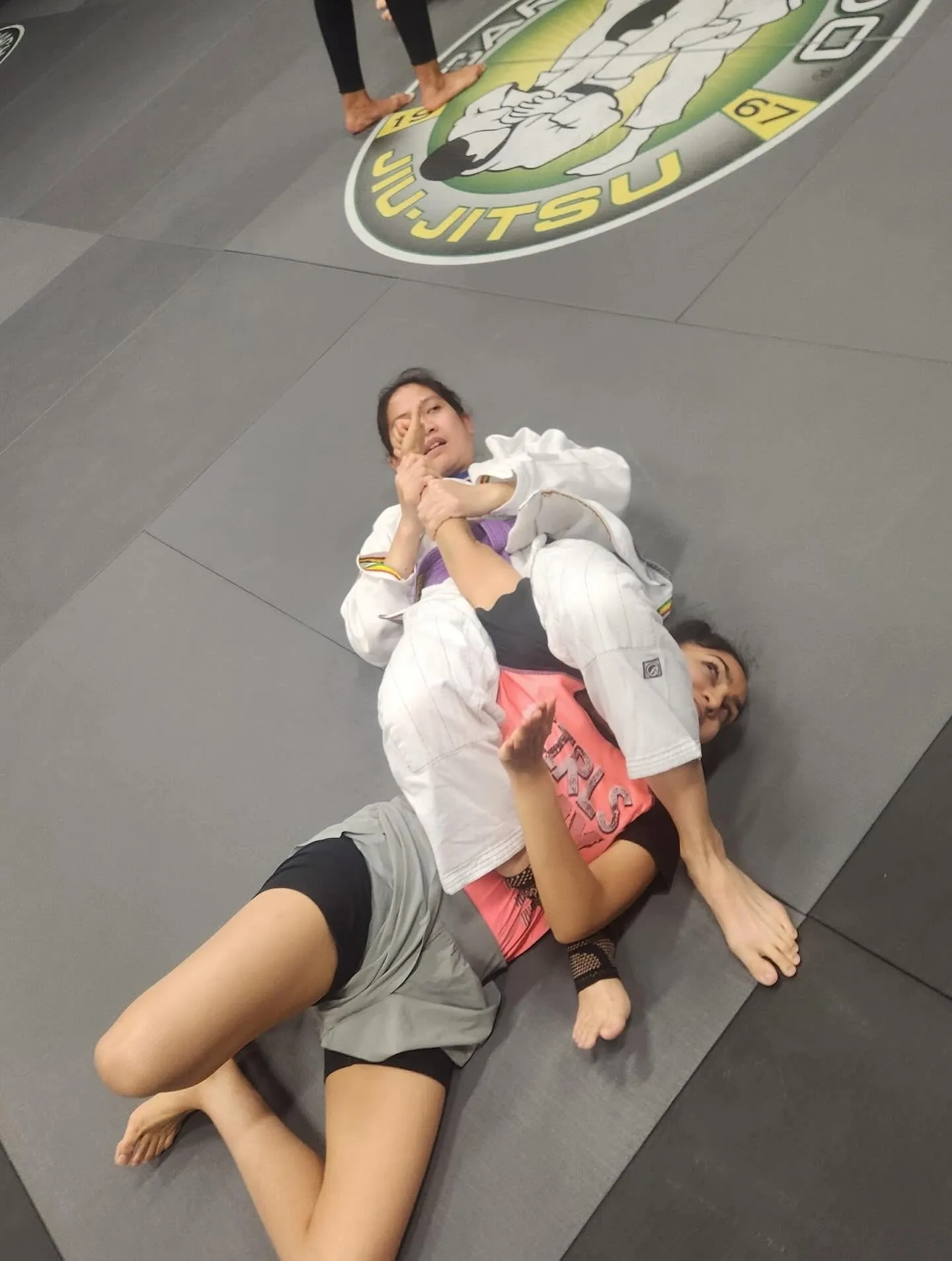 Two women training Brazilian Jiu-Jitsu together at Machado Method in Carrollton, TX