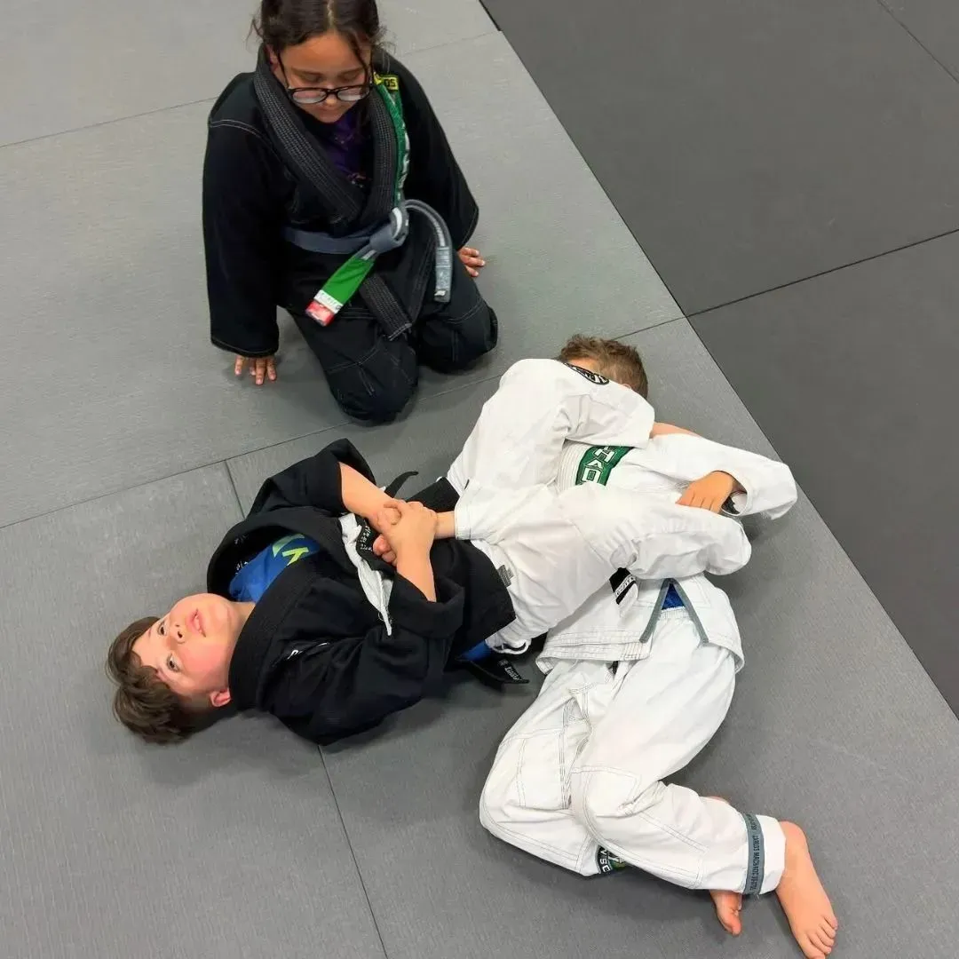 Two young Machado Method students drilling jiu-jitsu on the mat in Carrollton, TX