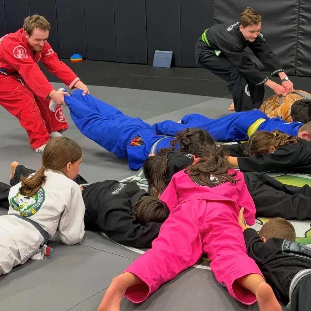 A group of Machado Method kids playing a team game during a jiu-jitsu class in Carrollton, TX
