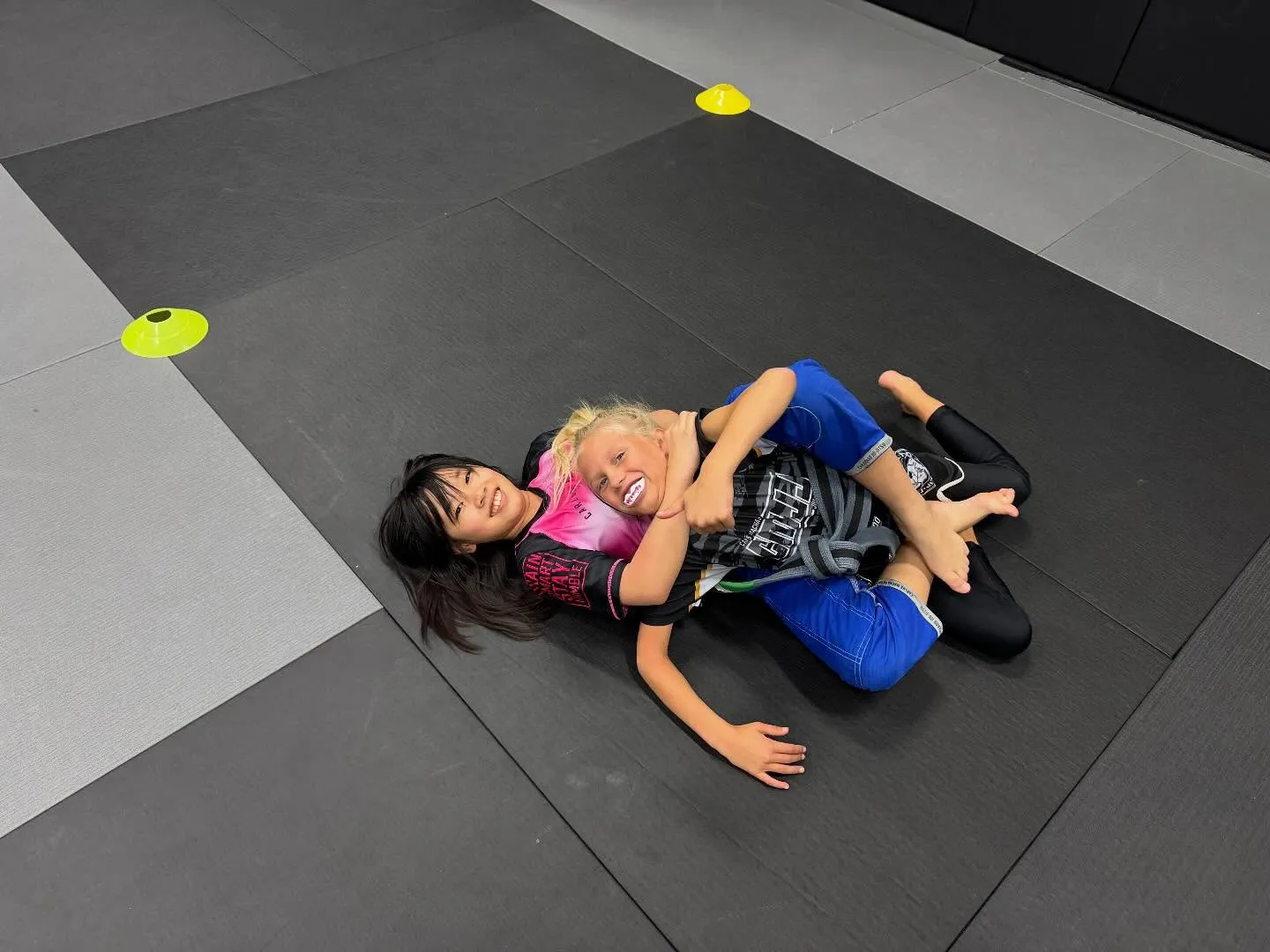 Two Machado Method youth students rolling on the mat in Carrollton, TX