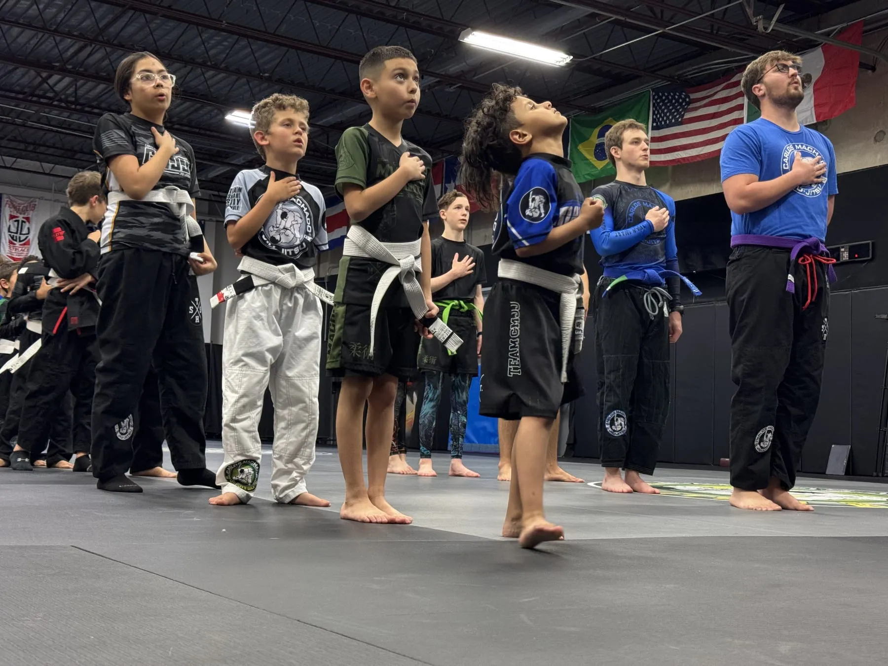 Jaguars students standing with a hand over the heart before class at Machado Method in Carrollton, TX