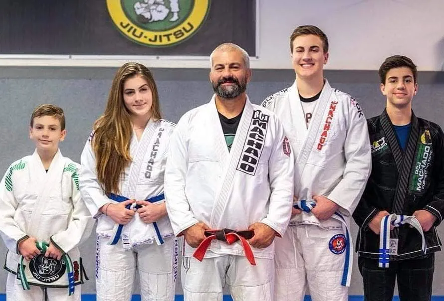 Carlos Machado with his family and students in their gis at the Machado Method academy in Carrollton, TX