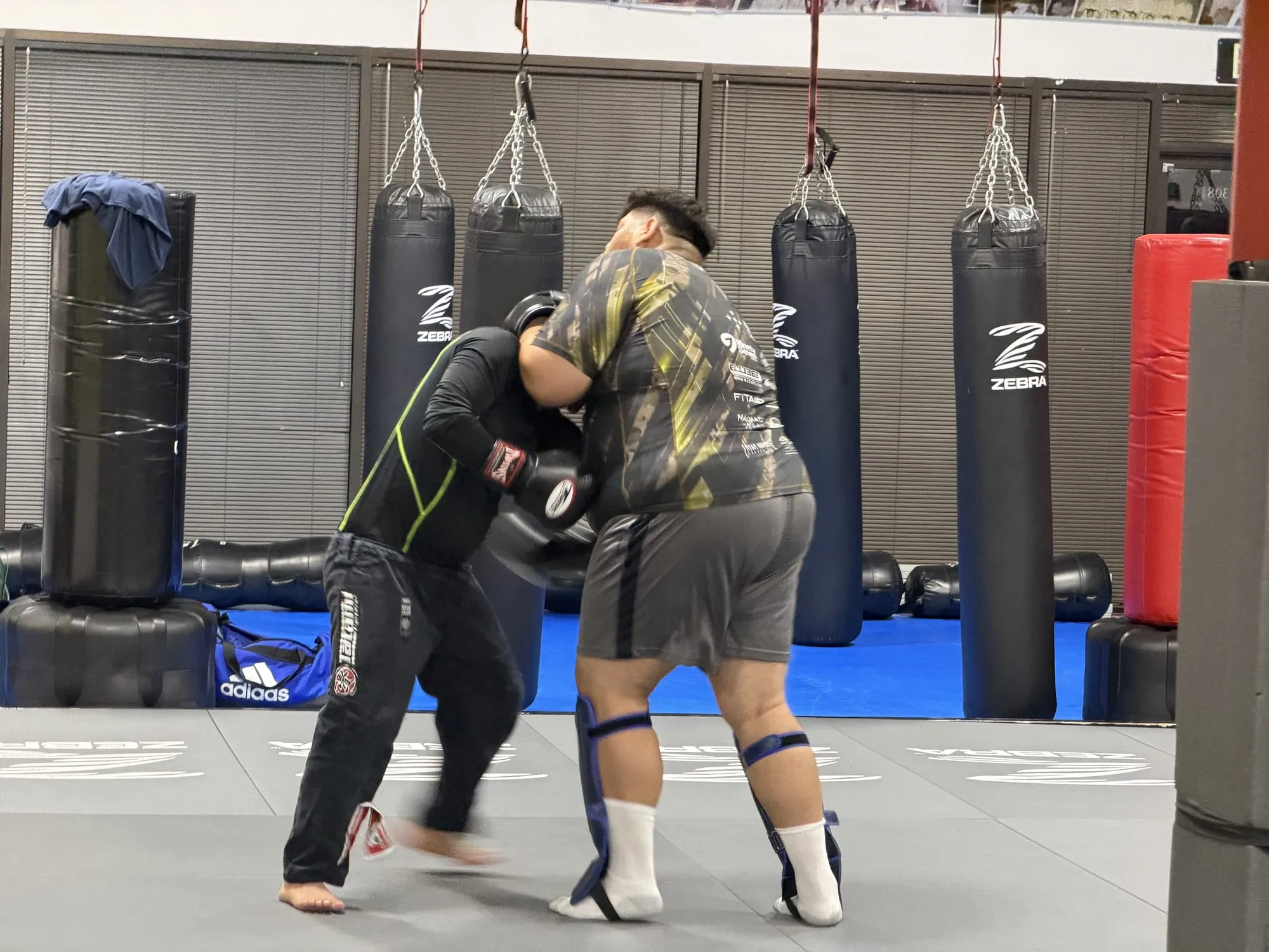 A member working the heavy bags in the striking area at Machado Method in Carrollton, TX