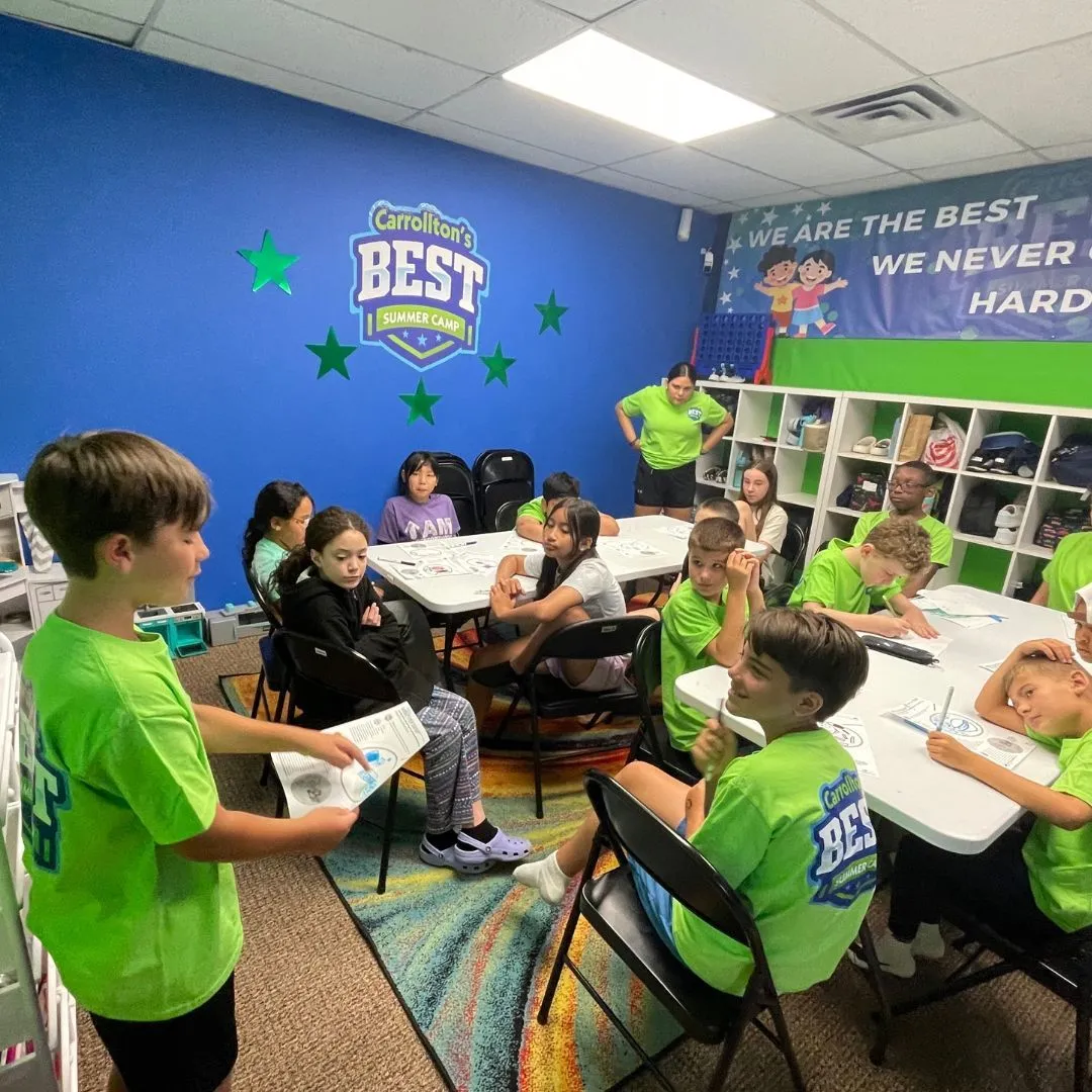 Machado Method summer campers at the tables under the Carrollton’s BEST Summer Camp banner in Carrollton, TX