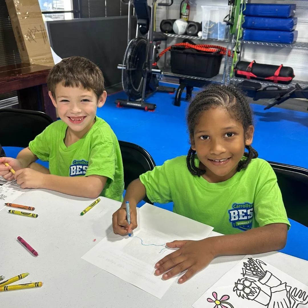 Two Machado Method summer campers coloring at a table in Carrollton, TX