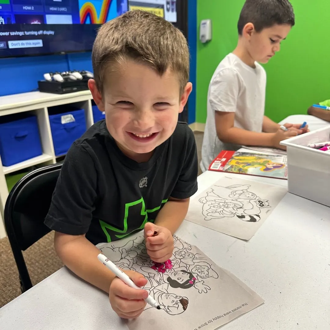 A Machado Method summer camper coloring during a camp activity in Carrollton, TX