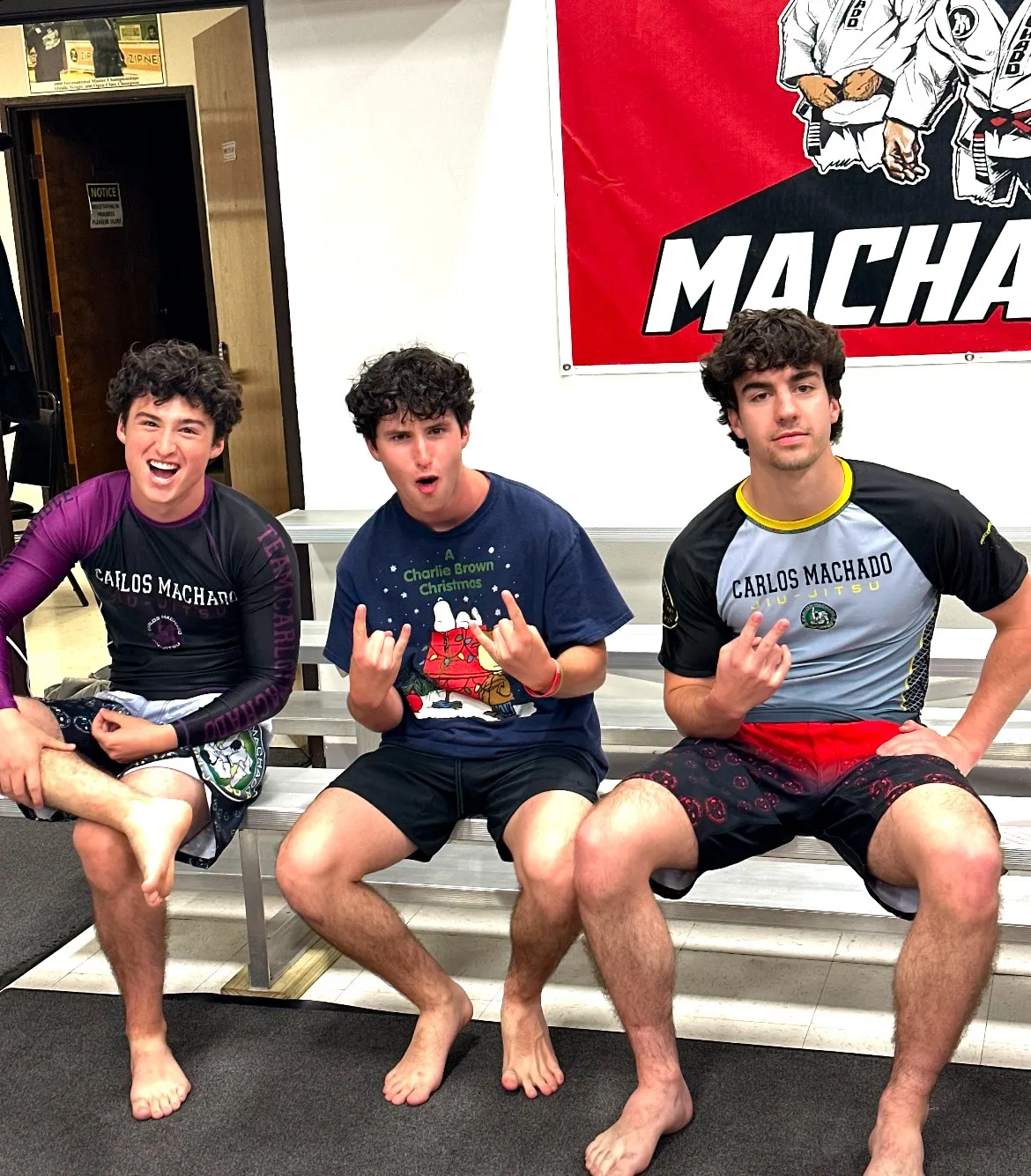 Three teenage Machado Method students in Carlos Machado gear laughing together between classes in Carrollton, TX